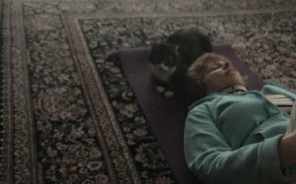 Women and cat on a yoga mat.